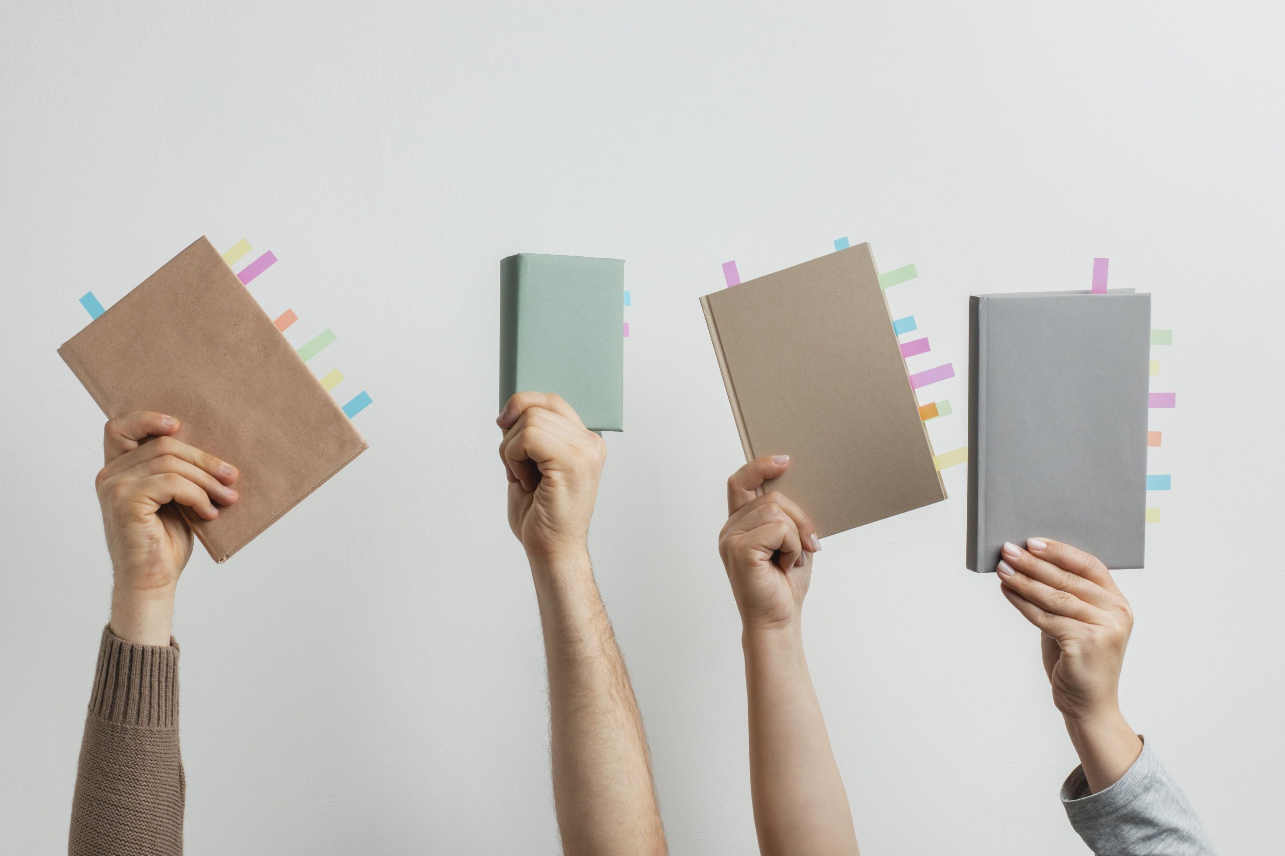 Hands holding books with sticky notes